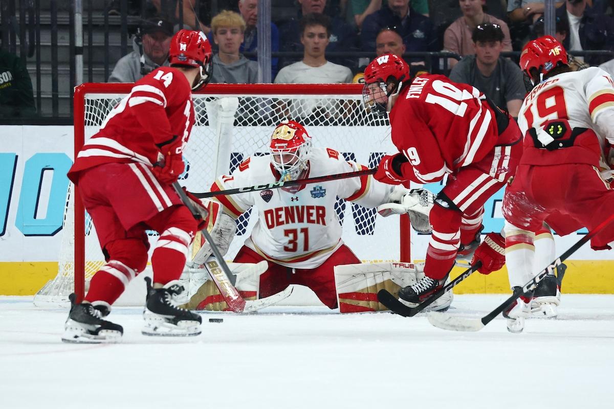Wisconsin forecheckers crowd the front of the Denver net in the 2026 Frozen Four final